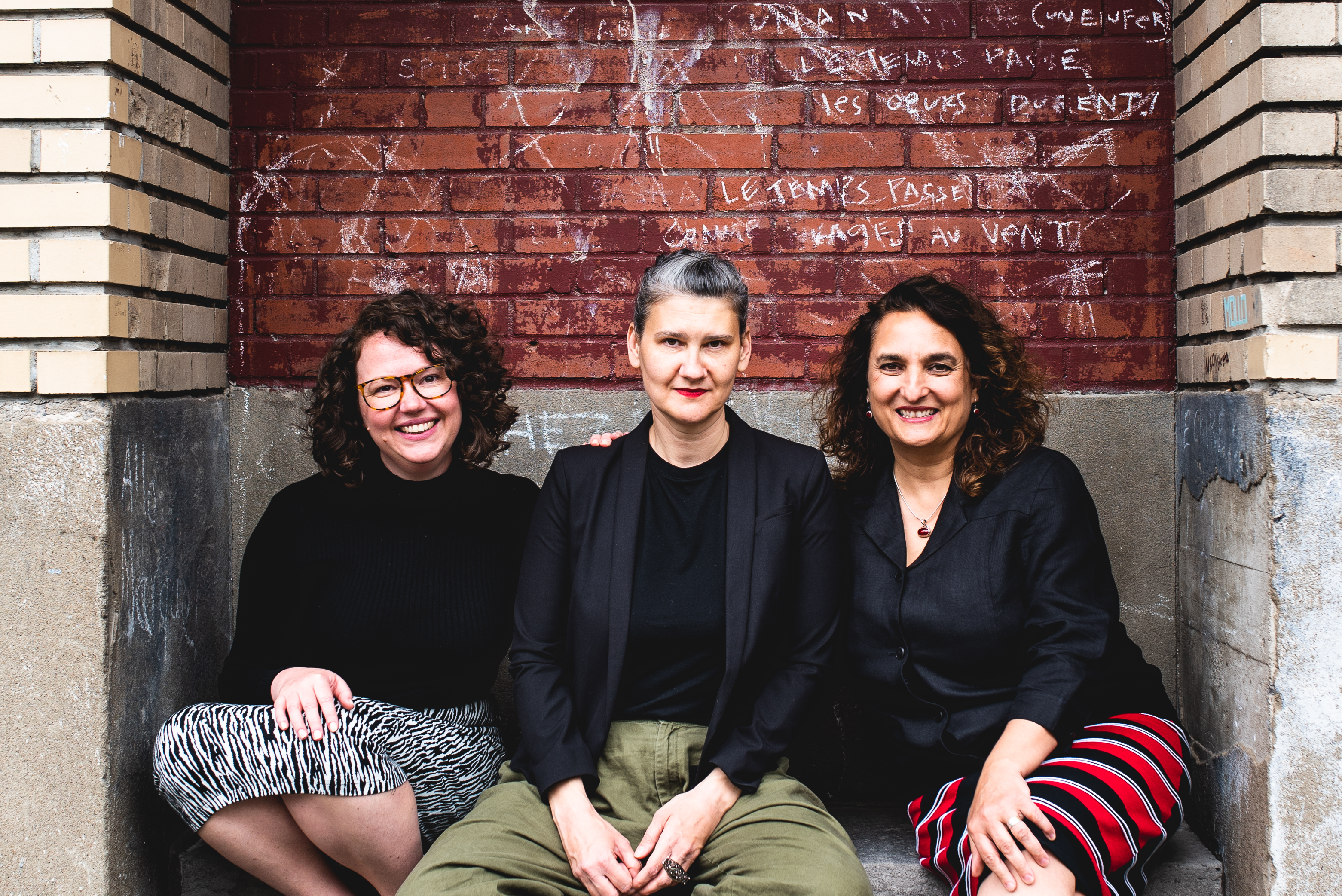 Photo of three women sitting on a stoop